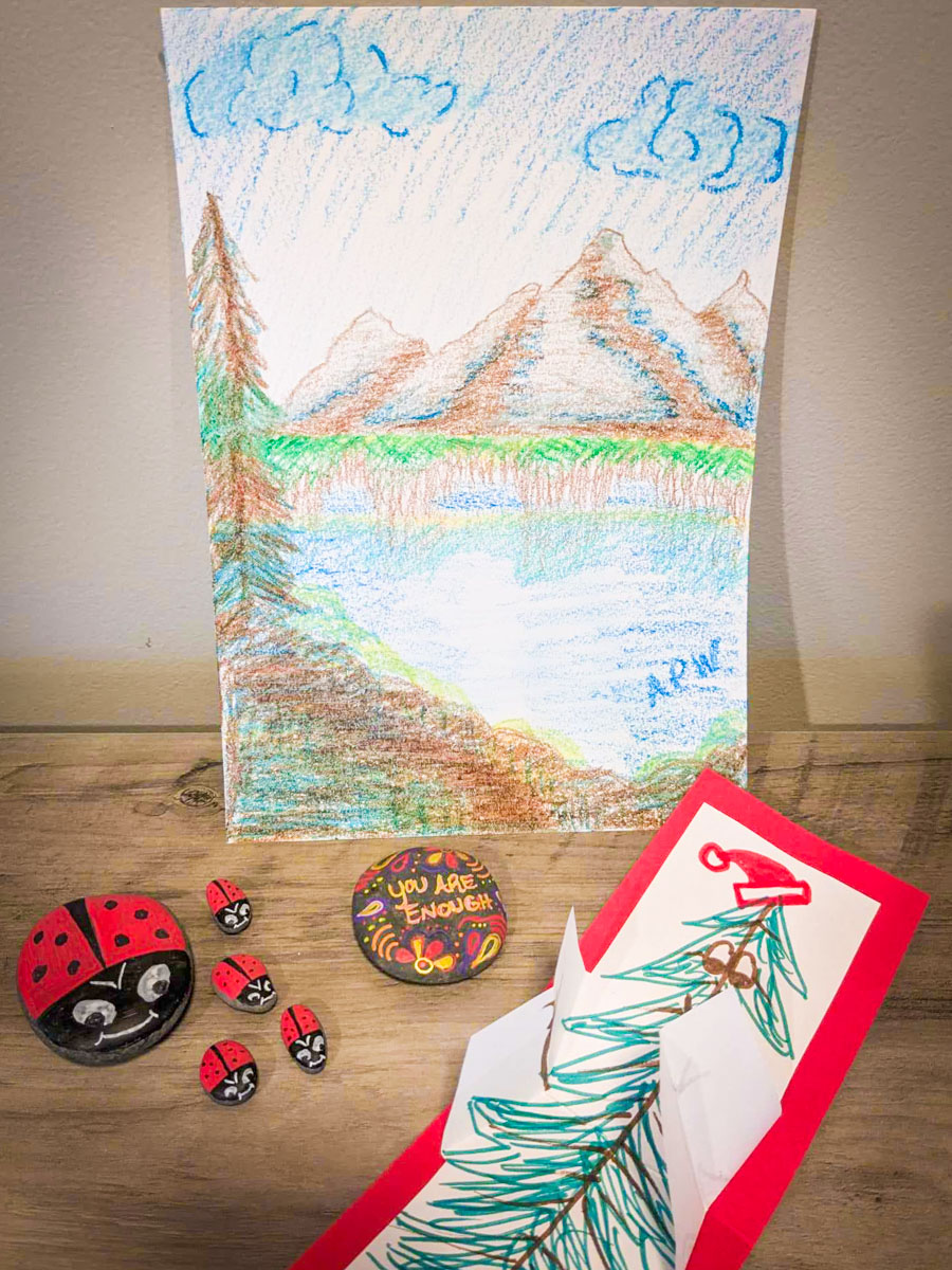 crayon drawing, painted rocks, and paper card