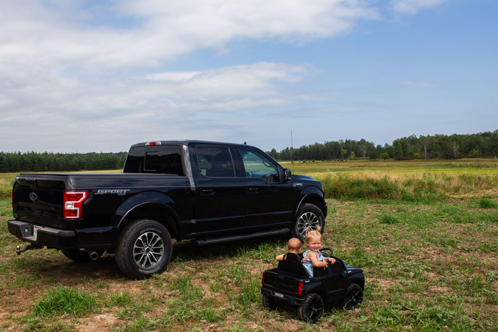 large black truck with toy truck and child riders