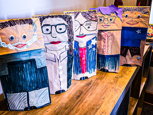 puppets made from paper bags on a wooden shelf