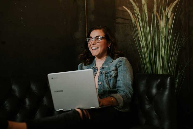 Image of smiling woman on laptop